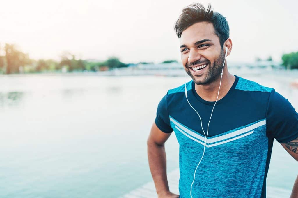 Cheerful young athlete outdoors by the river